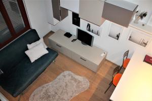 罗维戈Appartamento Via Mazzini的客厅配有沙发和书桌及电视