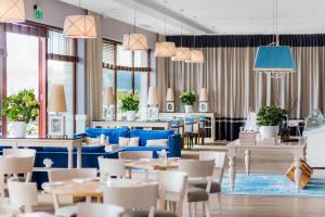 奥尔什丁Tiffi Boutique Hotel的餐厅设有蓝色的桌椅和窗户。