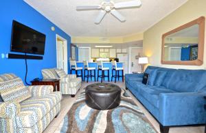 基韦斯特Sunrise Suites Big Kahuna Suite #202的客厅配有蓝色的沙发和椅子