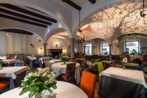 贝拉吉奥Hotel Florence的餐厅配有白色的桌椅和鲜花,