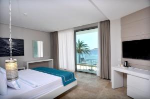 奥塔肯特Luga Boutique Hotel & Beach的酒店客房设有一张床和一个大窗户