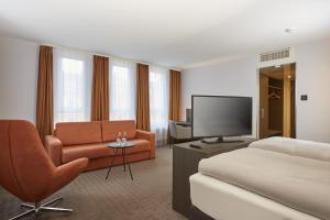 拜罗伊特拜罗伊特王宫H4酒店的酒店客房,配有床和电视