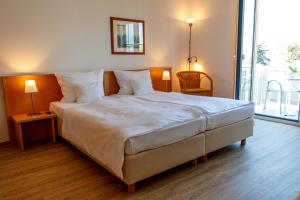 奥斯特巴德·哥伦Inselhotel Rügen的卧室配有一张带白色床单和枕头的大床。
