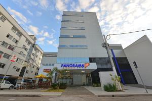 伊帕廷加Hotel Panorama Economic的一座高大的白色建筑,上面有标志