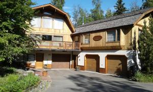 Eagle RiverAlaska Chalet Bed & Breakfast的大型木制房屋,设有2扇车库门