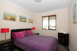 圣殿海岬桑迪菲特休闲公寓的一间卧室设有紫色的床和窗户