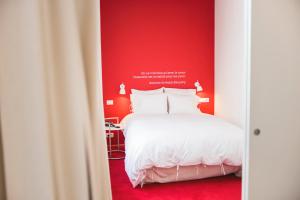 布鲁塞尔Smartflats - Pacific Brussels的卧室配有白色的床和红色的墙壁