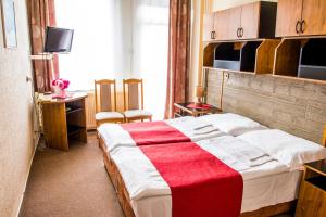 斯尼纳龟井酒店 的一间卧室配有一张带红白毯子的床