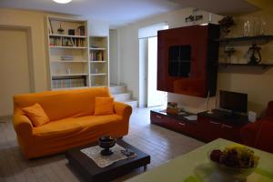 巴勒莫Daysin Apartments的客厅配有橙色沙发和电视