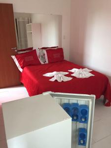 布鲁马迪纽Chalés Colina de Casa Branca的一间卧室配有红色的床和2条白色毛巾