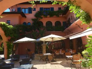 圣让-德吕兹尚塔克高尔夫康体酒店的一个带桌椅和遮阳伞的户外庭院。