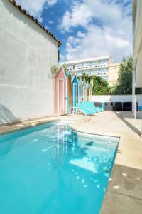 坎帕斯蒂利亚Apartments Beach 4U - Can Pastilla的一座带蓝色椅子的游泳池,位于大楼旁