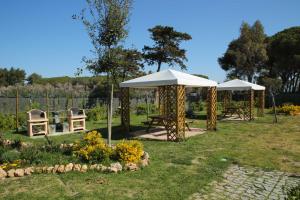 普林托迪斯卡利诺La Residenza del Golfo的花园内2张野餐桌和遮阳伞