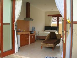沙努尔Fruits Villa的一间带一张床和椅子的卧室