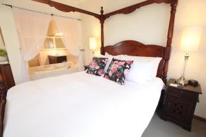 麦克拉伦谷红酒玫瑰住宿加早餐旅馆的卧室配有一张带白色床单和枕头的大床。