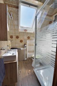 鲁尔河畔米尔海姆Ferienwohnungen Saarn的带淋浴和盥洗盆的浴室以及窗户。