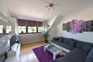 鲁尔河畔米尔海姆Ferienwohnungen Saarn的客厅配有蓝色的沙发和紫色地毯