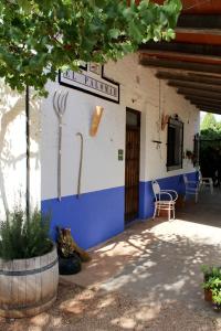奥萨德蒙铁尔Casas Rurales el Palomar的蓝白色的建筑,配有桌子和椅子