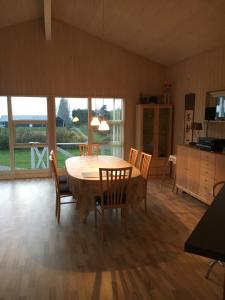 埃贝尔托夫特Three-Bedroom Holiday Home in Ebeltoft的一间带桌椅的用餐室和一间厨房