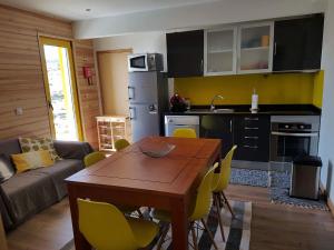 科维良Casa da Bela Vista - Serra da Estrela的厨房以及带桌子和黄色椅子的用餐室。
