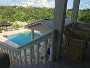 普罗维登西亚莱斯岛Sagusta Gardens PLS的阳台设有游泳池和2把椅子