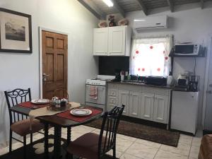 普罗维登西亚莱斯岛Sagusta Gardens PLS的一间带桌子的厨房和一间带桌椅的厨房