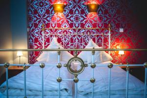 威斯巴登亚历山大酒店的一间卧室配有一张红色和白色墙壁的床