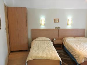 卡斯托里亚Hotel Orestion的酒店客房设有两张床和两个橱柜。