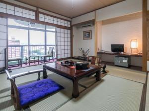 高知昭荣河滨日式旅馆的一间带桌子的客厅和一个阳台