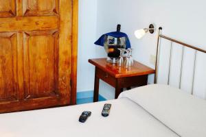莱乌卡Hotel Rizieri的一间卧室配有一张床和一张桌子,配有两个遥控器