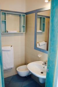 莱乌卡Hotel Rizieri的一间带水槽、卫生间和镜子的浴室