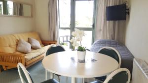 Owaka卡特林斯地区汽车旅馆的客厅配有桌子和沙发
