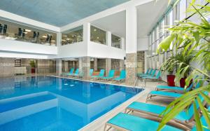 拿撒勒Ramada Olivie Nazareth的一座带蓝色椅子的酒店游泳池
