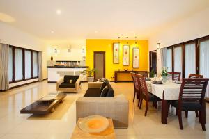 克拉玛斯巴厘岛橙色别墅的一个带桌子的大客厅和一间餐厅