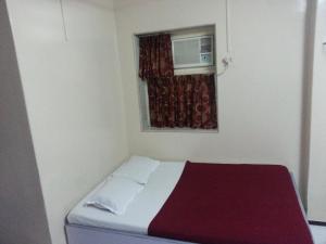 孟买New Metro Guest House的一间小卧室,配有床和窗户