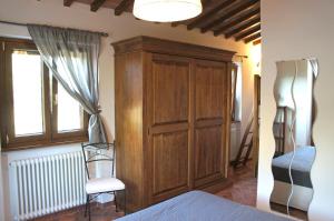 普拉托韦基奥Agriturismo Mandrioli的卧室配有木制橱柜,位于床边