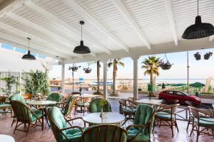 罗希姆诺波塞冬酒店的一间带桌椅的海景餐厅