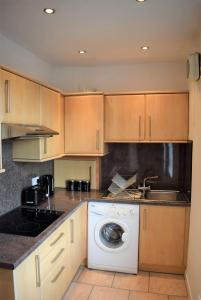 格兰奇茅斯Kelpies Serviced Apartments MacGregor- 2 Bedrooms的厨房配有洗衣机和水槽