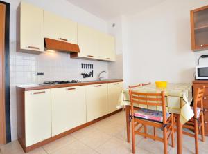 比比翁Residence Millennium的厨房配有白色橱柜和桌椅