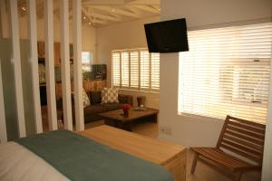 布鲁堡史特兰Freshhh的一间卧室配有一张床、一张沙发和一台电视