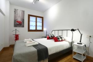 宏达瑞比亚Tolosa by Smiling Rentals的一间卧室配有红色和黑色枕头的床