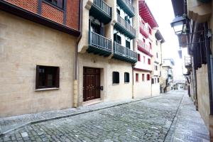 宏达瑞比亚Tolosa by Smiling Rentals的一条有建筑物的小巷里的鹅卵石街道