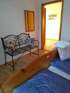 BrinjaheFerienwohnung Wisbek的一间卧室,卧室内配有一张床和一把椅子