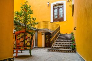 普埃布拉Hotel Marqués del Ángel的黄色的建筑,设有楼梯和椅子