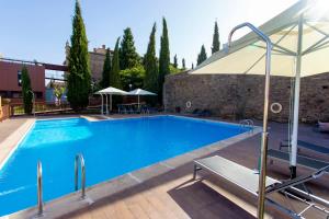 加洛维拉斯阿尔孔尼塔尔桥酒店的一个带遮阳伞的大型蓝色游泳池