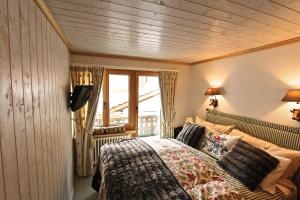 克洛斯特斯瑟纽斯Chalet Drusa的一间卧室设有一张床和一个大窗户