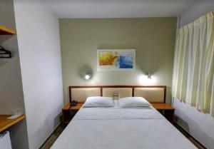 Rolim de MouraEcos Hotel Tourist的一间卧室配有一张带白色床单的大床