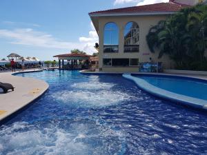坎昆海滨套房公寓的度假村内的一个蓝色海水游泳池