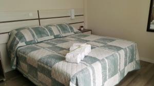 邦比尼亚斯Pousada Bomar Bombinhas的一间卧室配有一张床,上面有两条毛巾