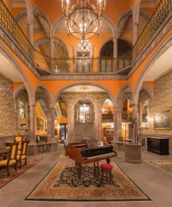 圣路易斯波托西Hotel Museo Palacio de San Agustin的中间设有钢琴的豪华客房